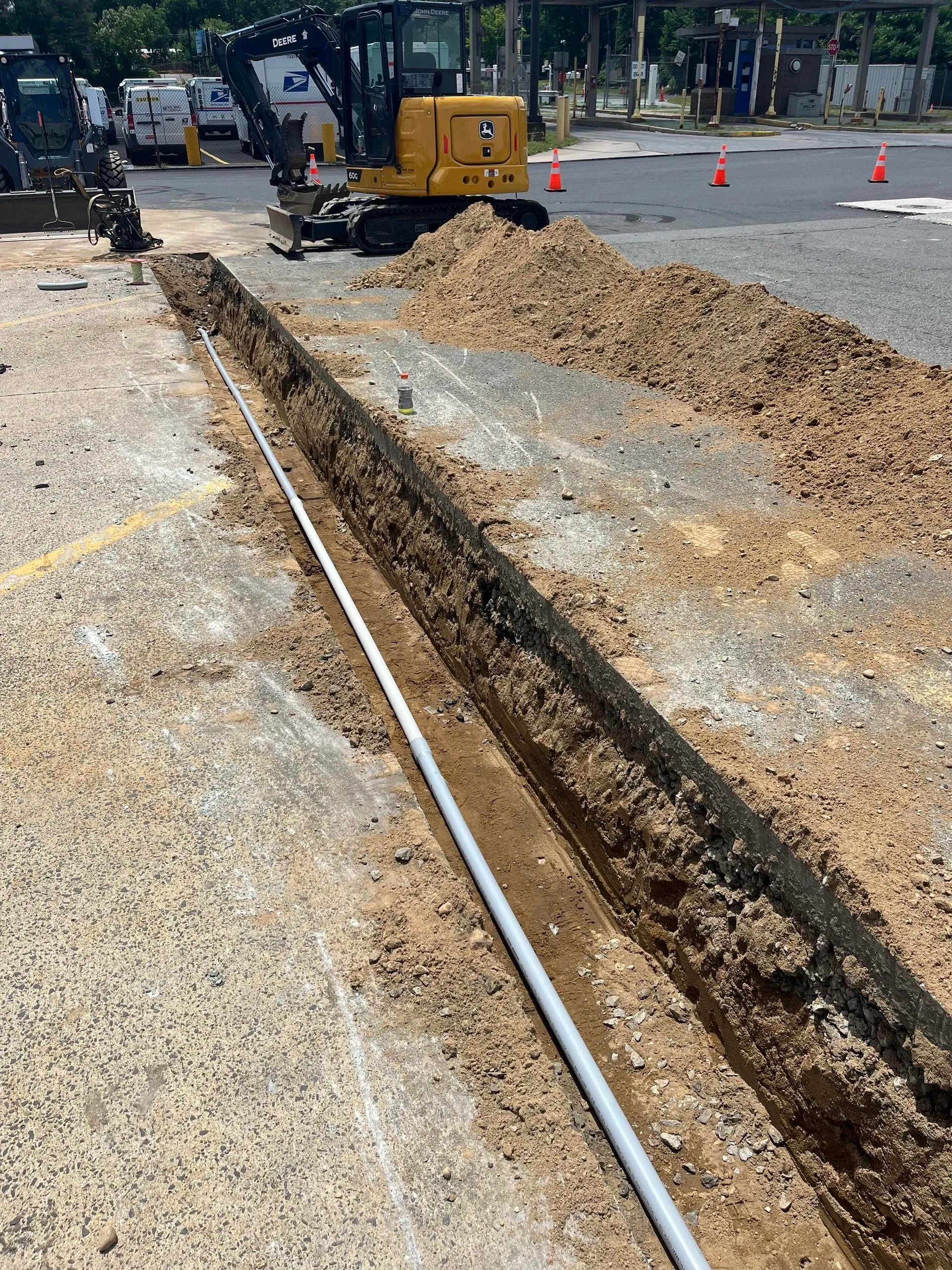 Construction site with trench and machinery.