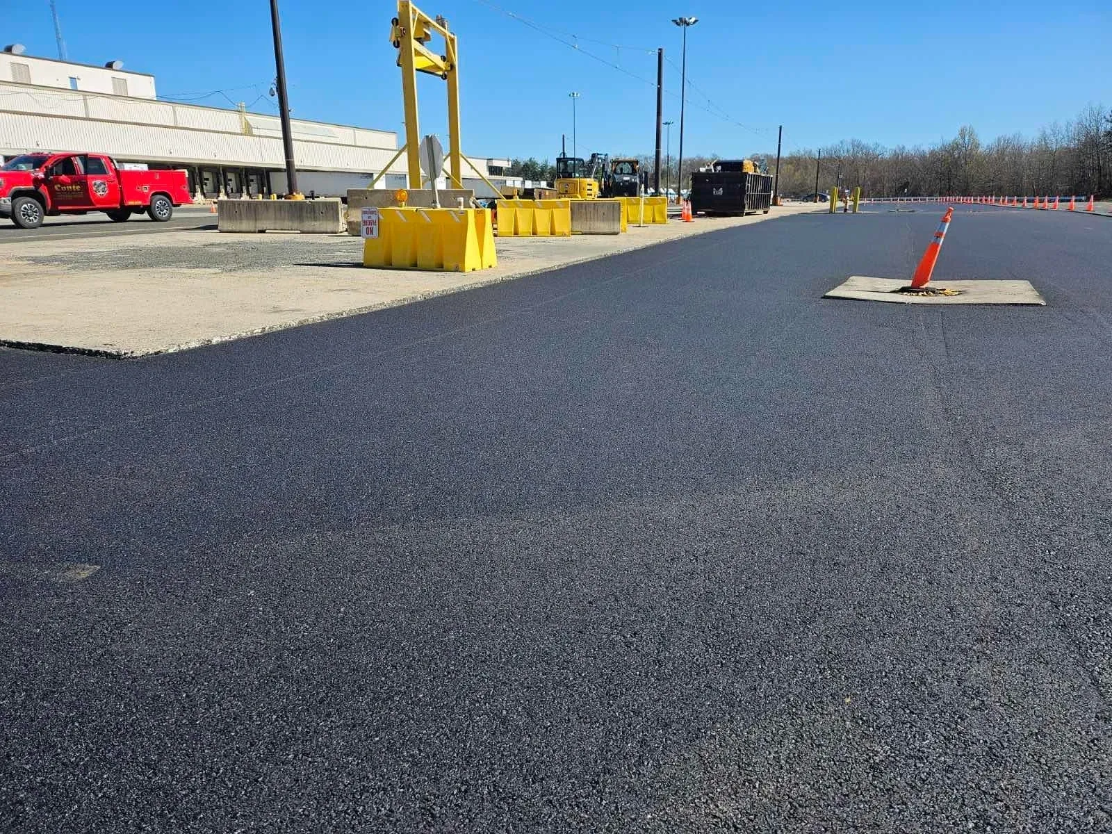 Freshly paved road with construction cones.