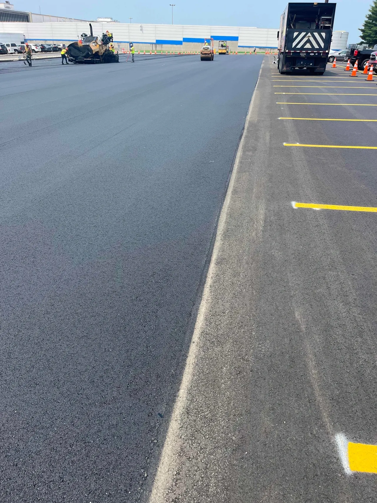 Freshly paved parking lot with visible markings.