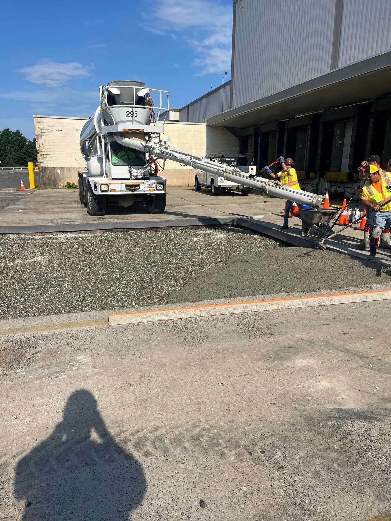 Construction workers pouring concrete from truck.