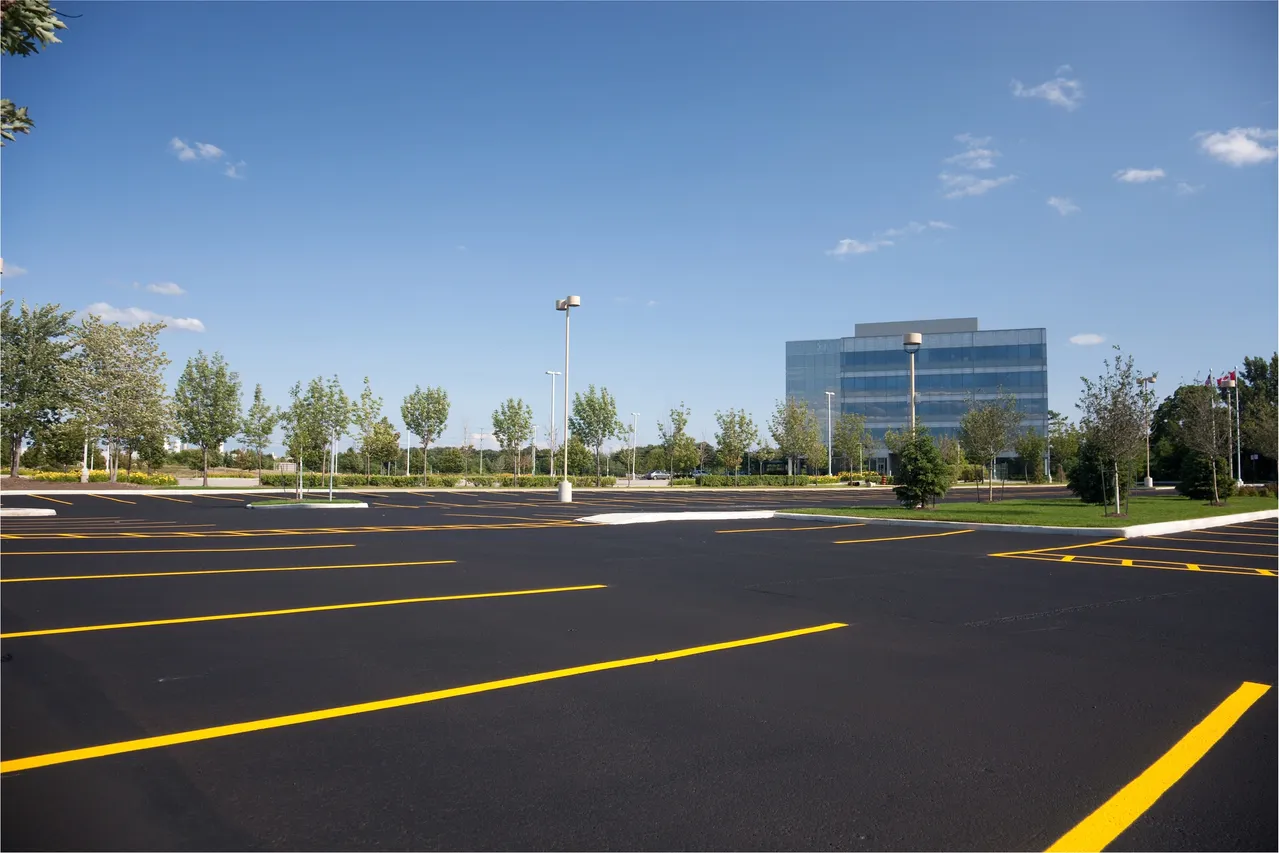 Empty parking lot with office building background.