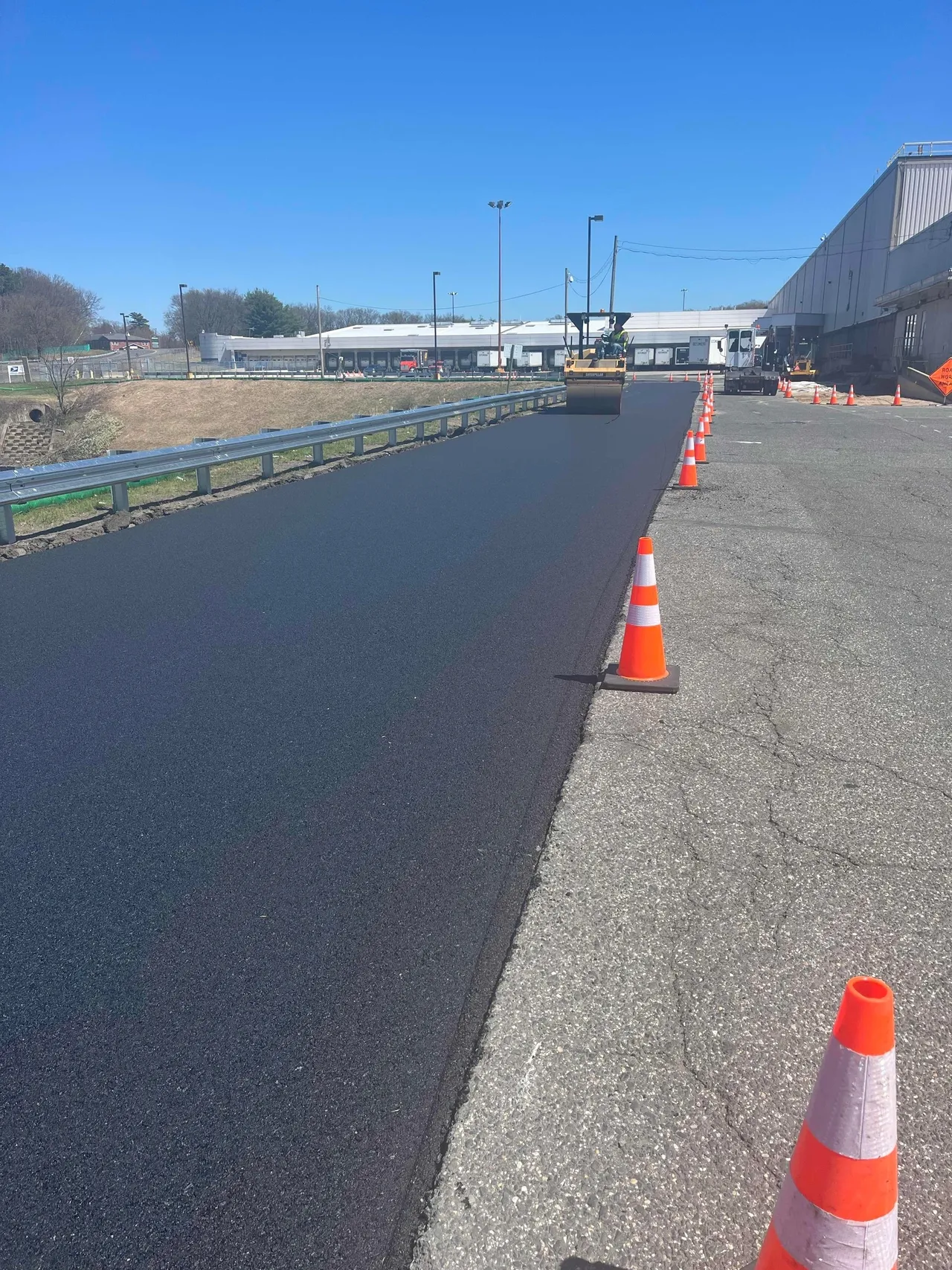 Paved road with traffic cones and roller.