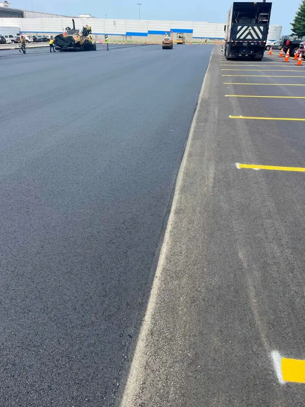 Asphalt paving project in progress, showcasing freshly laid asphalt surface and construction equipment, highlighting Conte Paving & Construction's expertise in durable paving solutions.