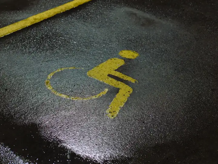 Accessible parking symbol stenciled on asphalt during line striping