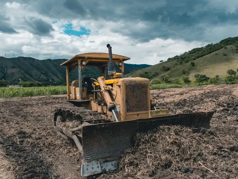 Bulldozer grading a field to the correct slope before paving