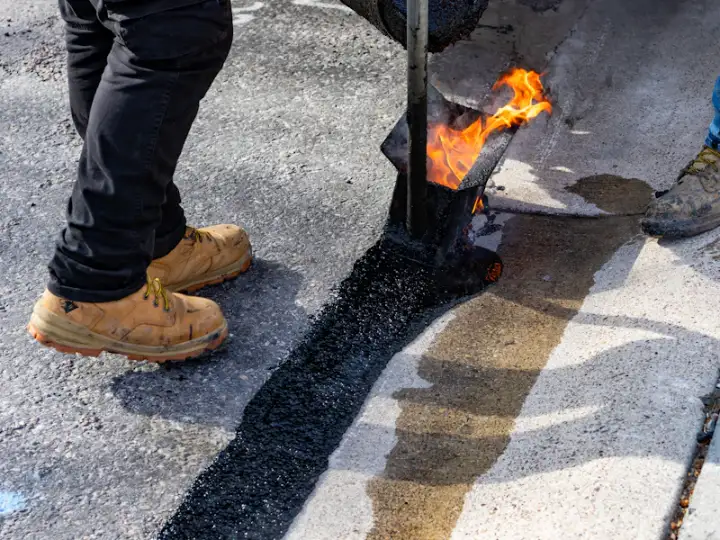 Crew sealing and patching damaged asphalt before an overlay