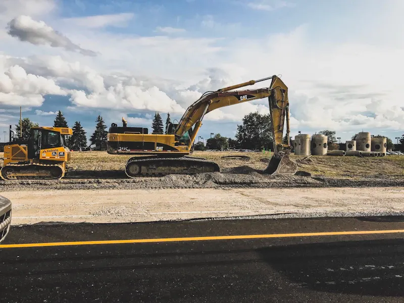 Excavator digging and grading soil on a job site