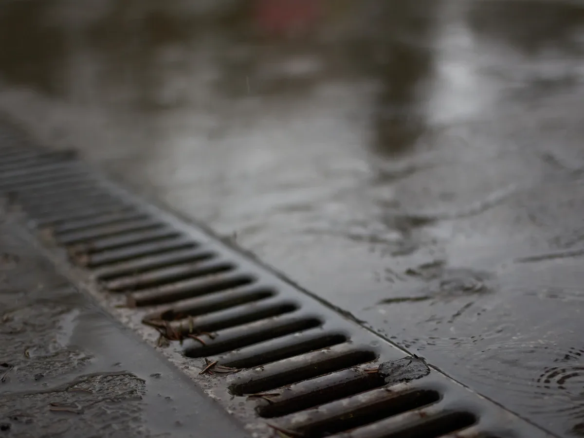 Metal storm drain set into graded concrete for proper drainage