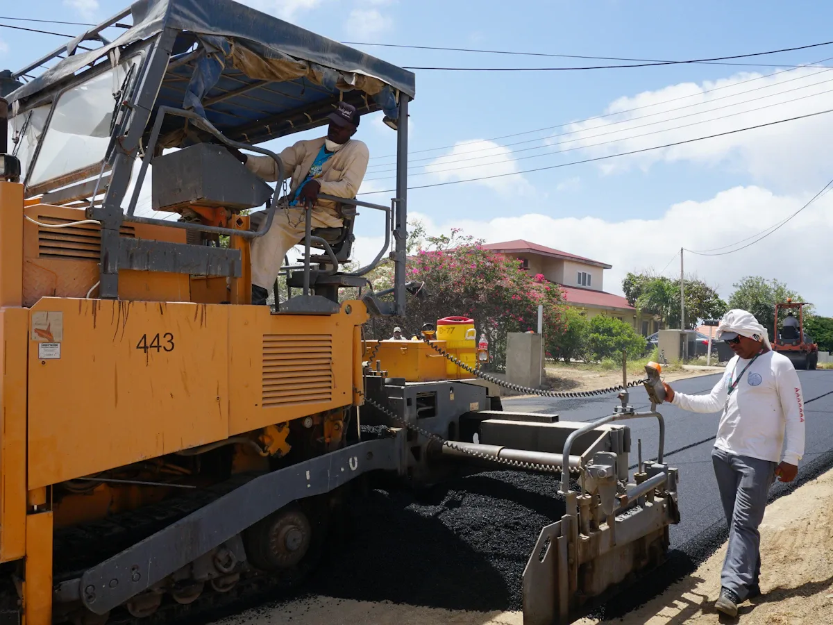 Paving crew laying fresh asphalt with a paving machine