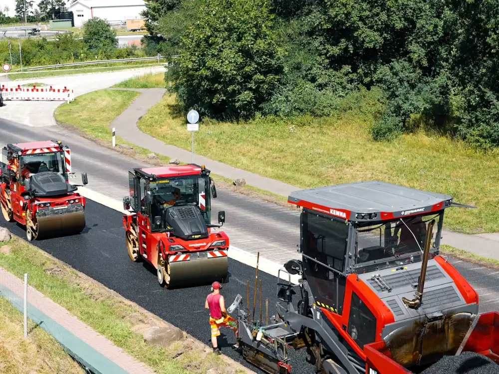 Road rollers and paver laying fresh asphalt