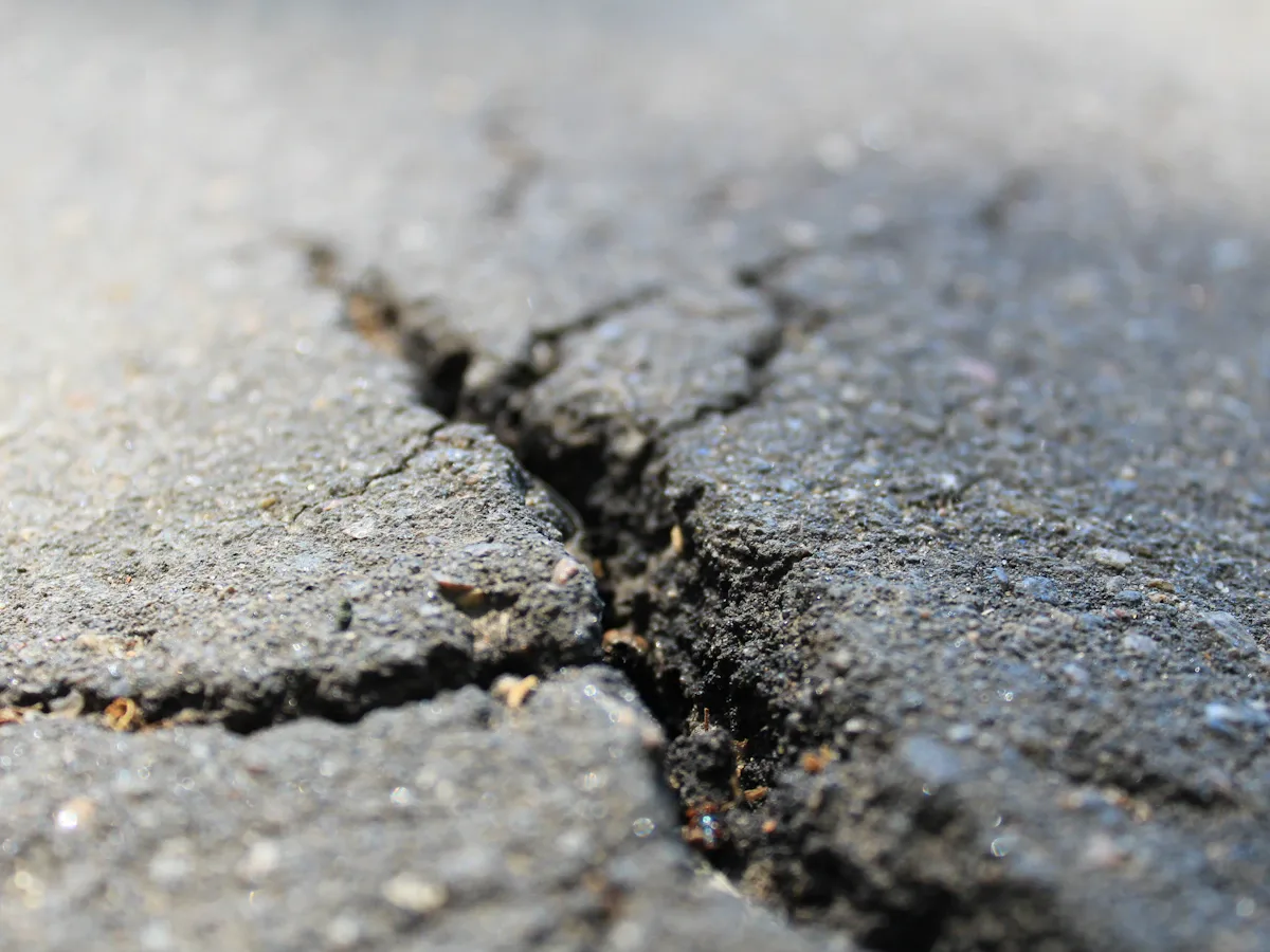 Thin crack running across an asphalt surface