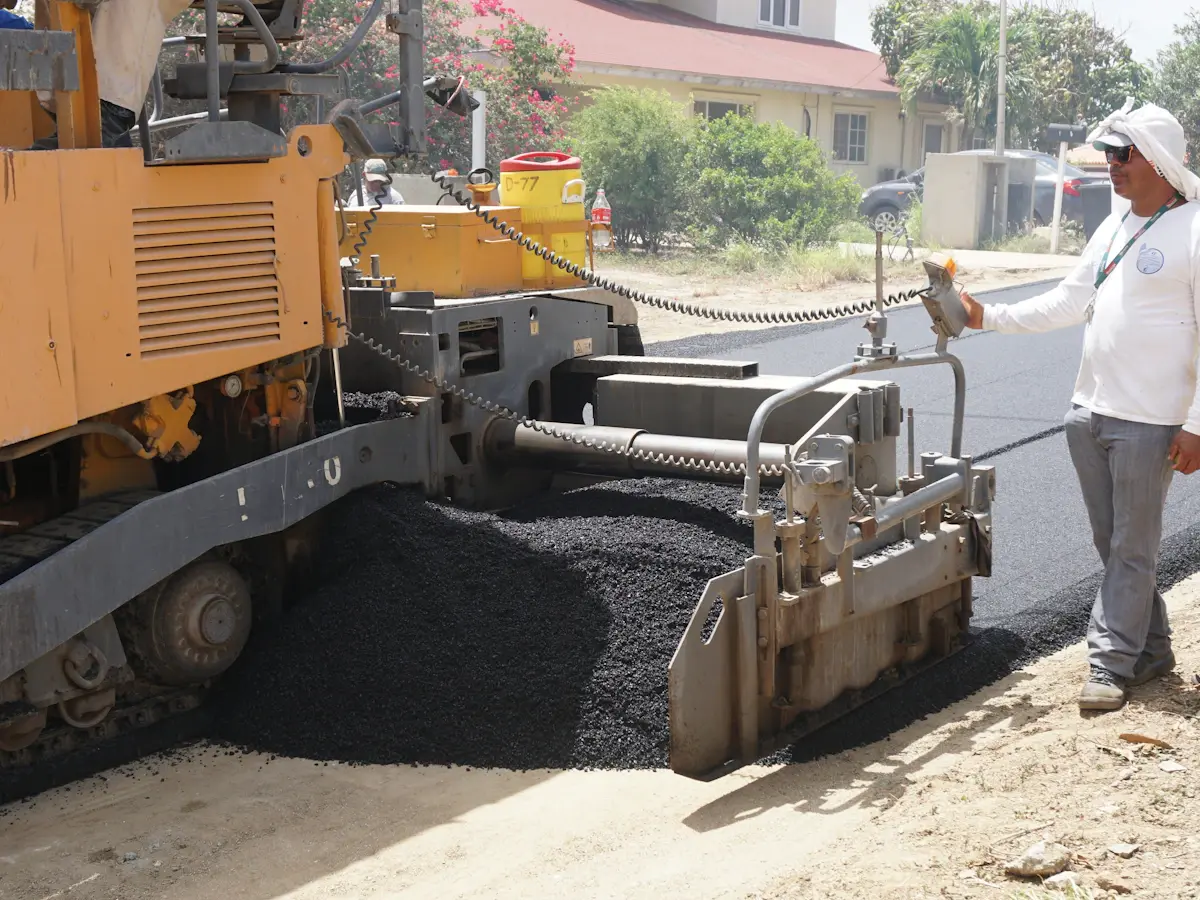 Worker operating an asphalt paving machine